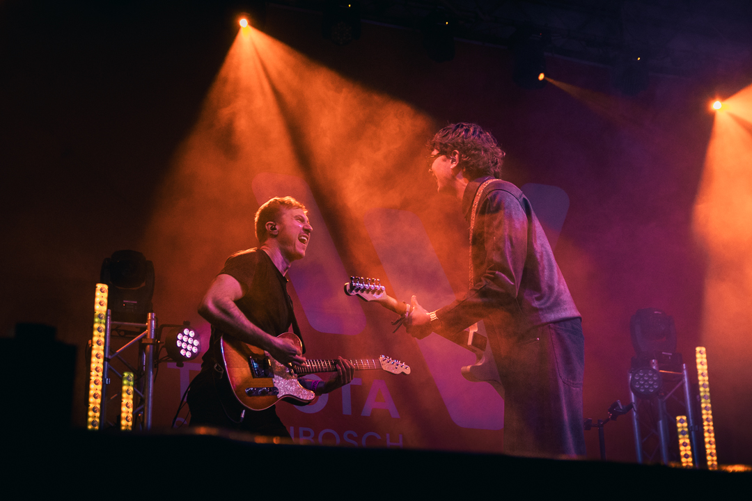 Moody lighting falls onto musicians on stage as they entertain the crowd.