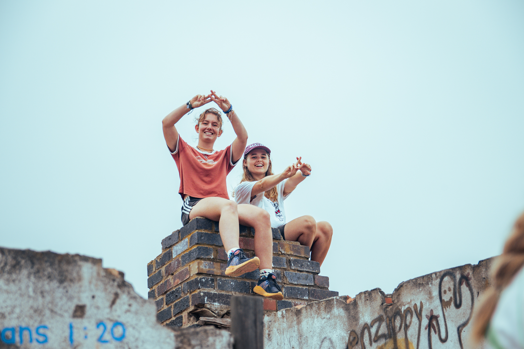 Stellenbosch students sitting on a wall and posing for a photo after their hike