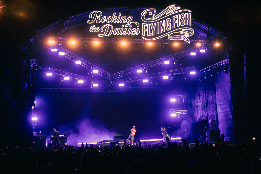 Wide view of a giant stage with crowds dancing in front at Rocking The Daisies