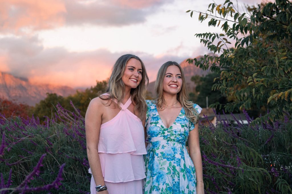 Girls smile against an orange sunset for their seniors dance photoshoot at Root 44 Stellenbosch