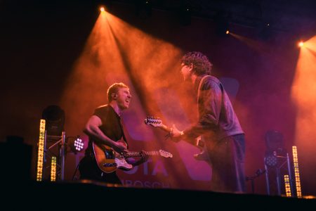 Moody lighting falls onto musicians on stage as they entertain the crowd.
