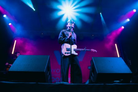 Will Linley silhouetted by a burst of blue light while on stage in Stellenbosch
