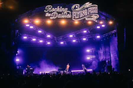 Distant stage foregrounded by massive crowds at music festival